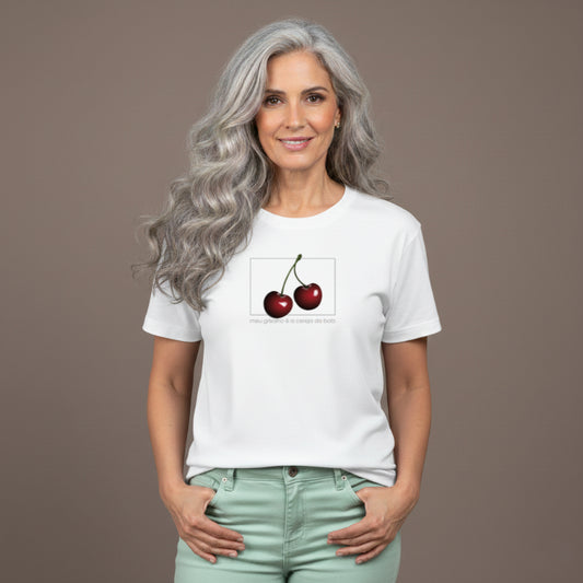 Jovem grisalha com a camiseta premium da marca Orgulho Gray com a frase Meu grisalho é a cereja do bolo e a estampa de duas cerejas. Moda para grisalhas pode ser divertida e irresistível. Celebre o seu grisalho feminino natural!